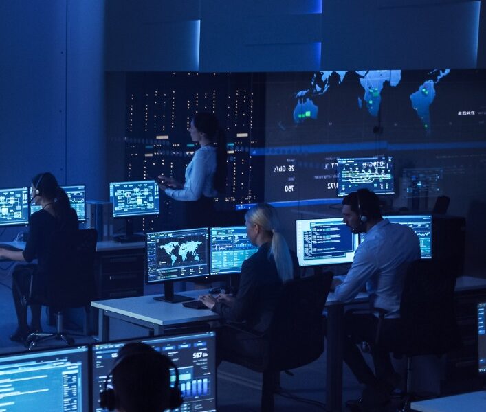 A group of people sitting at tables with computers.