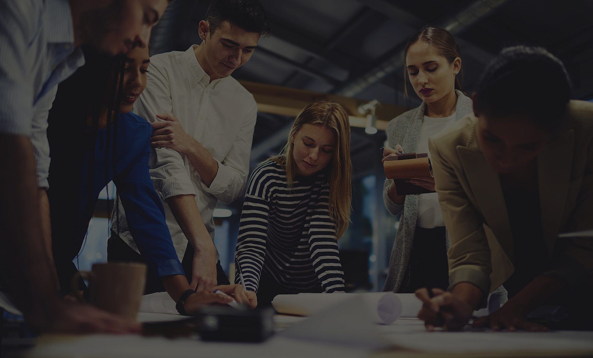 A group of people standing around a table.