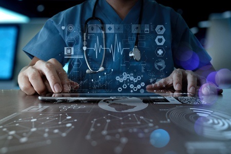 A doctor is using his tablet computer to diagnose the patient.