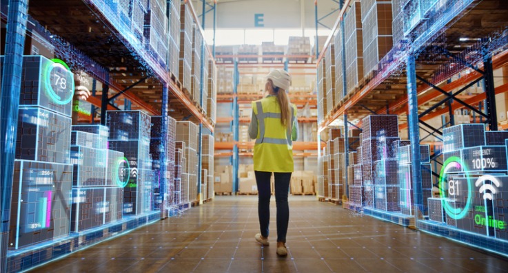 A woman in yellow vest standing inside of warehouse.