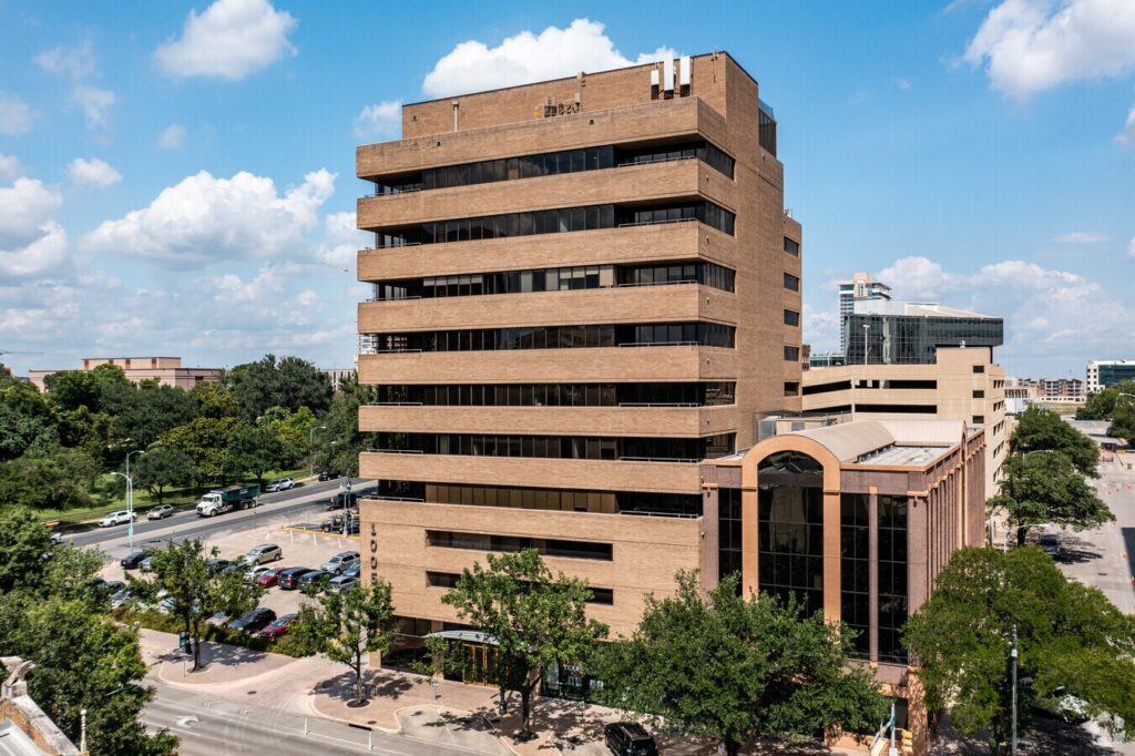 A large building with cars parked on the side of it.