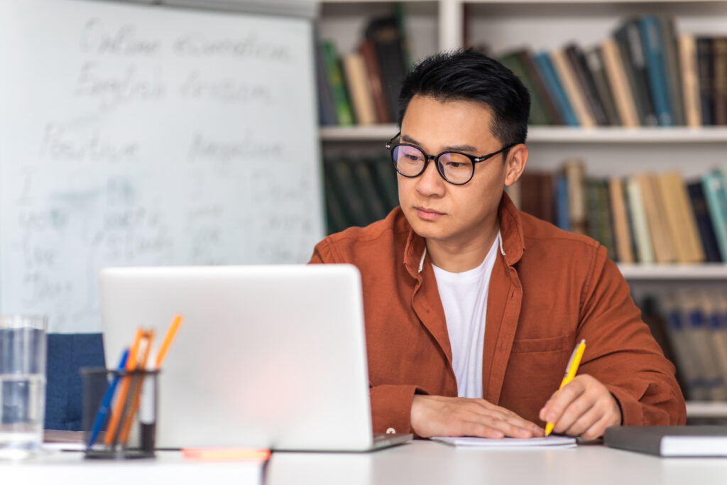 A man sitting at a table with a laptop.