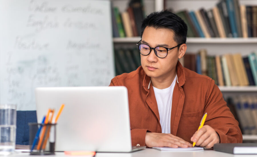 A man sitting at a table with a laptop.