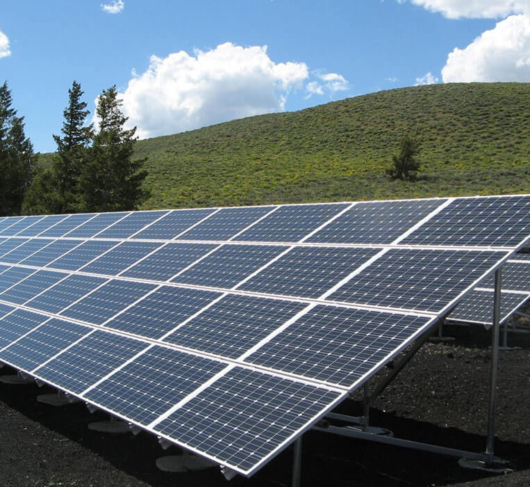 A large solar panel sitting in the middle of a field.