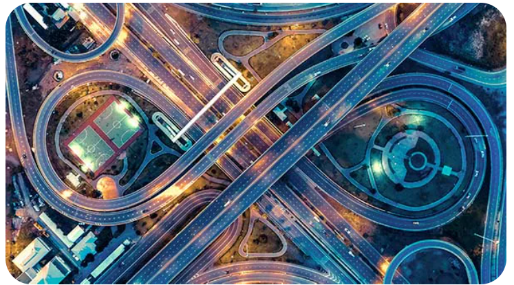 A view of an intersection from above at night.