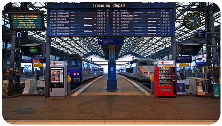 A train station with two trains on the tracks.