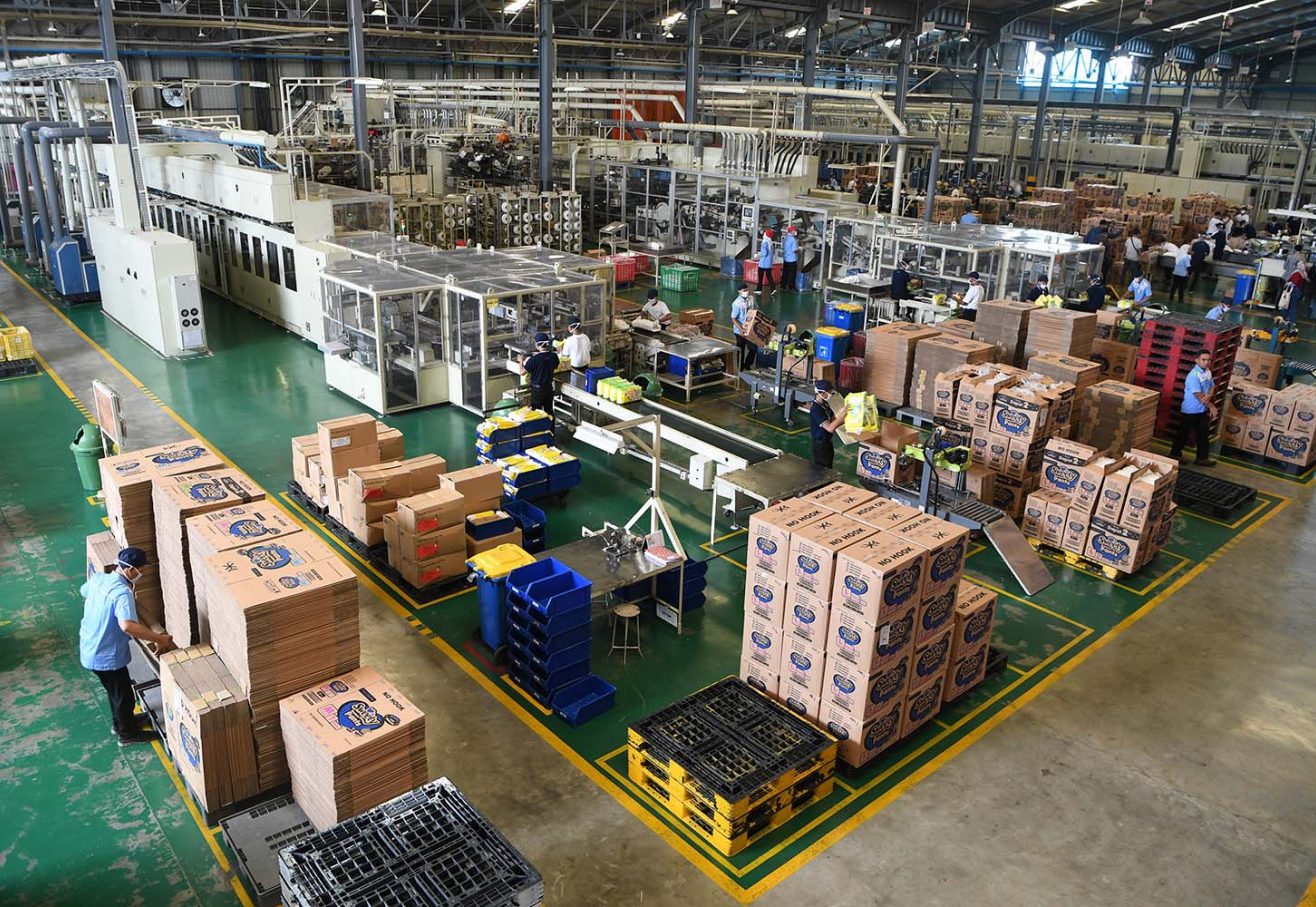 A warehouse filled with boxes and people working.