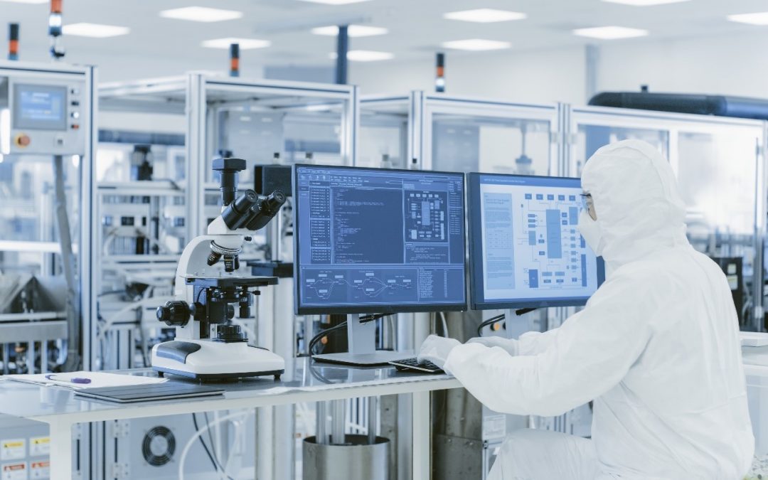 A man in white lab coat holding up a computer.